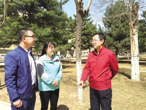 蔡禄在校园里与学生交流。